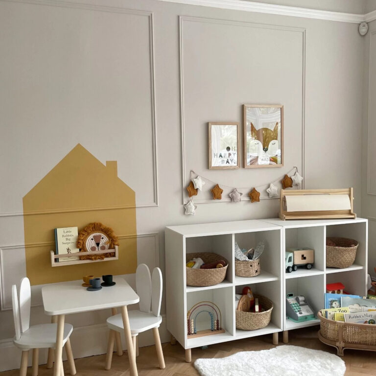 Children's playroom with a small table, chairs, and shelves with toys and decor.