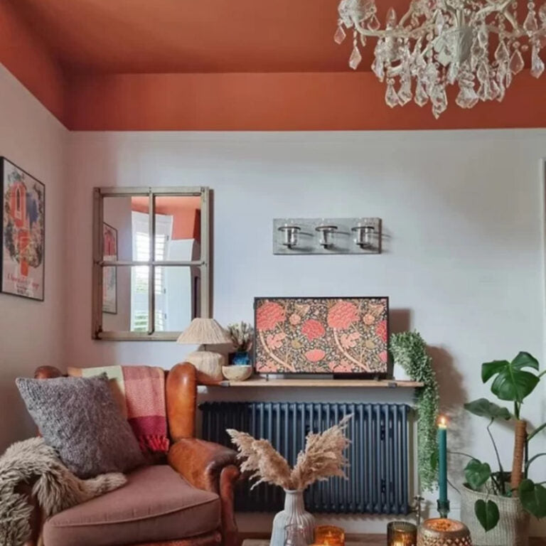Living room with a floral-patterned TV, wooden armchair, and decorative plants.