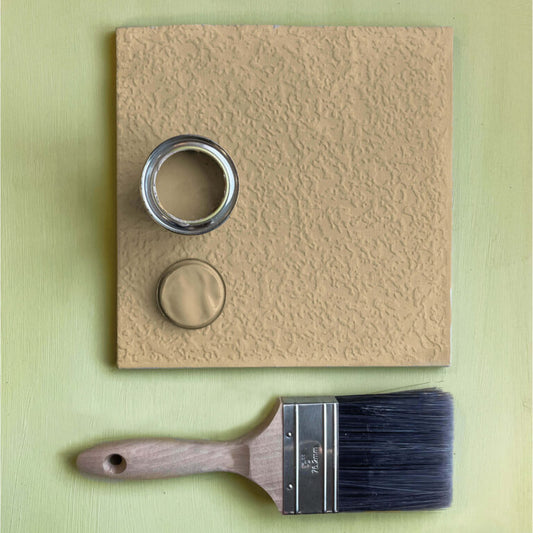 Textured beige panel with a paint can and brush on a green background