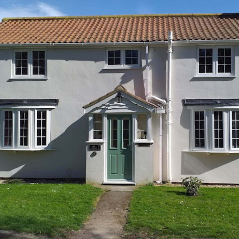 White house with a green door and red roof