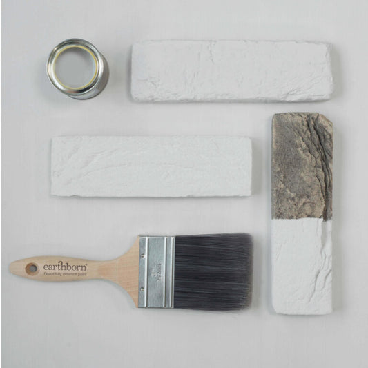 Paintbrush, painter's tape, and textured paint samples on a light gray background