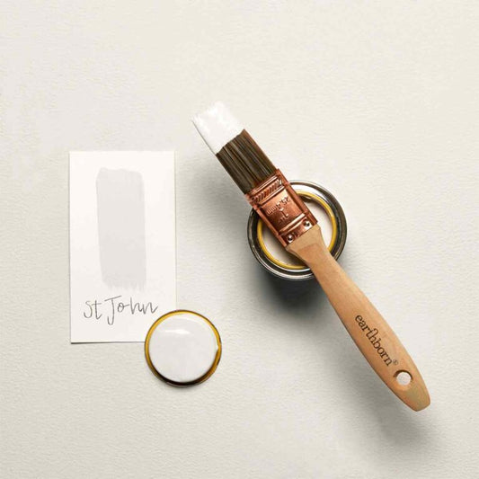 Paint brush and paint can on a light gray surface with 'earlham' branding.