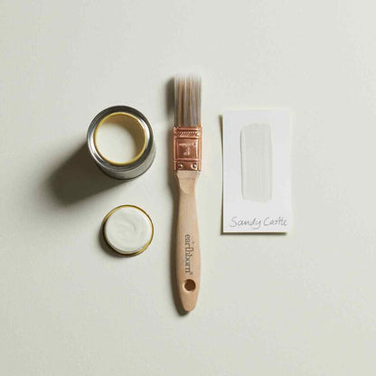 Paint can, brush, and sample on a light gray background