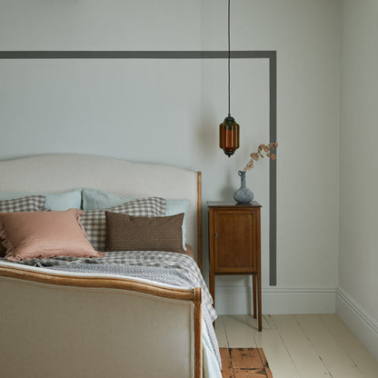 Bedroom with wooden bed, nightstand, and decorative lamp.