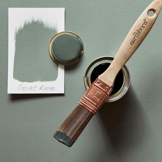 Paint brush and can of paint labeled 'earthborn' on a green background