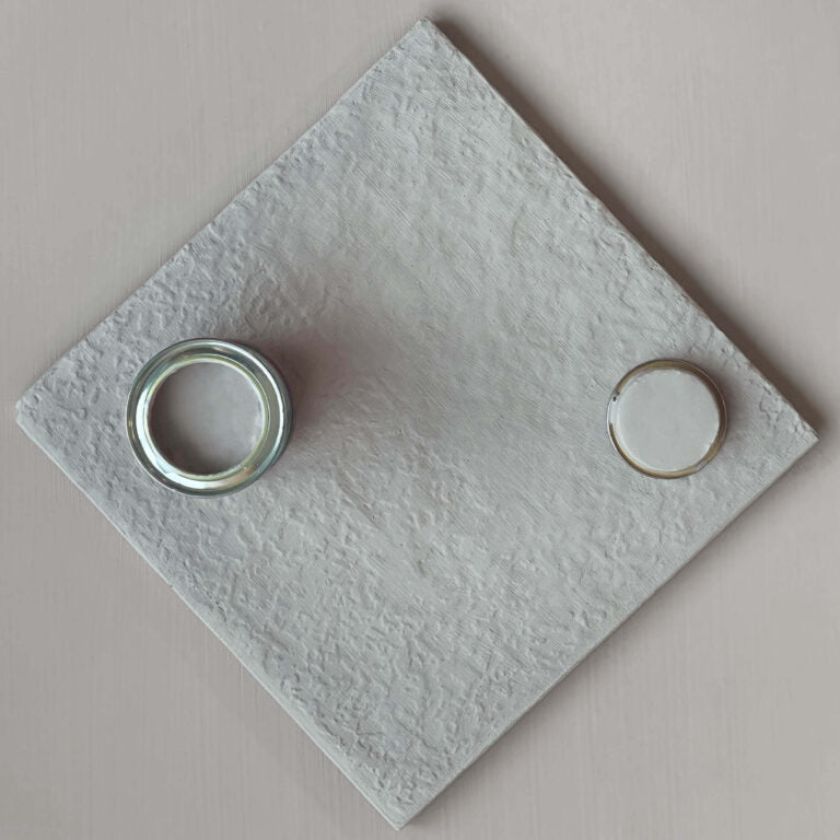 Textured gray square with two circular cutouts on a matching background