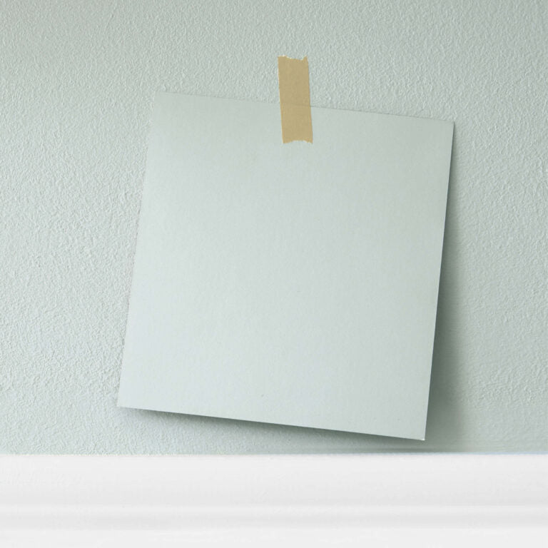 White sheet of paper taped to a light green wall