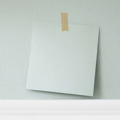 White sheet of paper taped to a light green wall