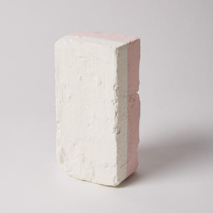 White brick with a pinkish-red interior on a light gray background