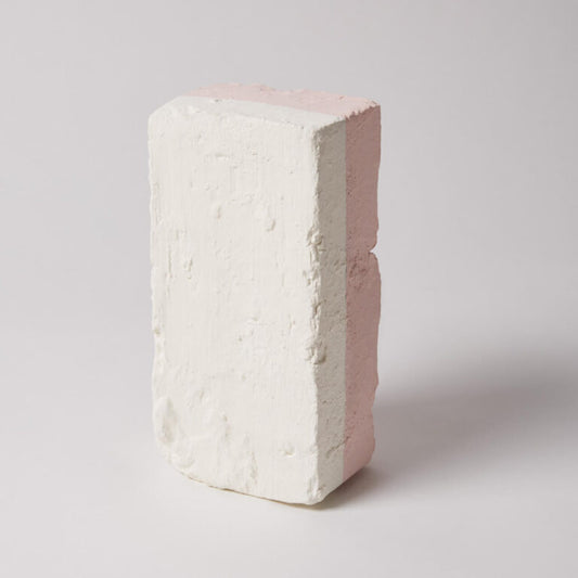 White brick with a pinkish-red interior on a light gray background