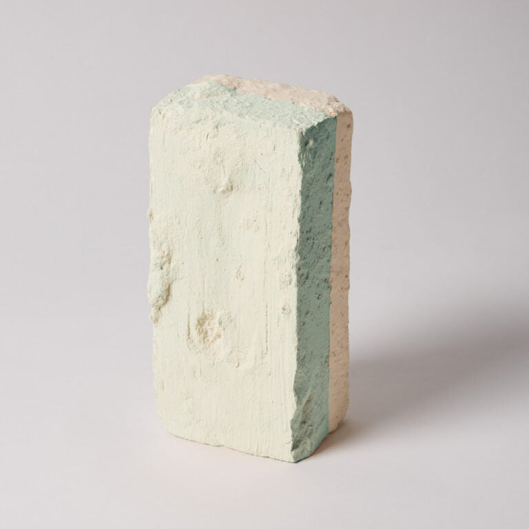 Multicolored brick with a gradient from beige to green on a light gray background