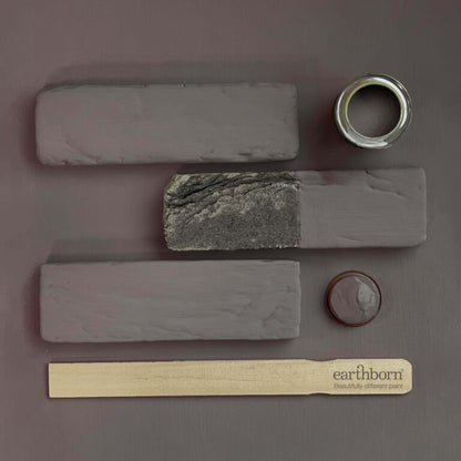 Collection of stone samples and a paint can on a gray background with 'earthborn' branding.