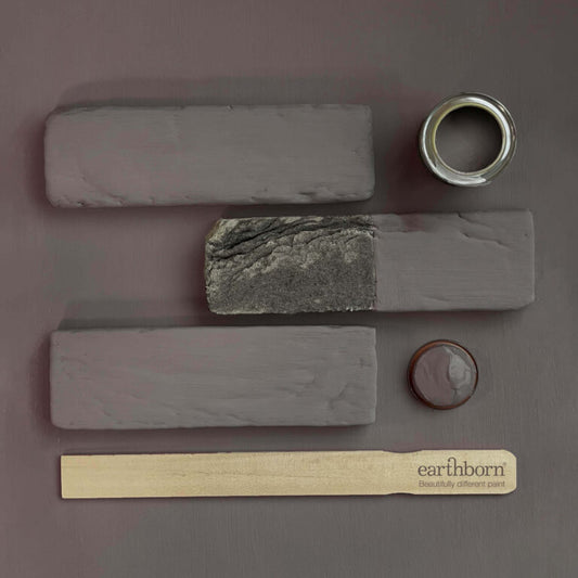 Collection of stone samples and a paint can on a gray background with 'earthborn' branding.