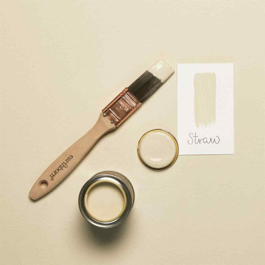 Paintbrush, paint can, and color swatch labeled 'Straw' on a beige background