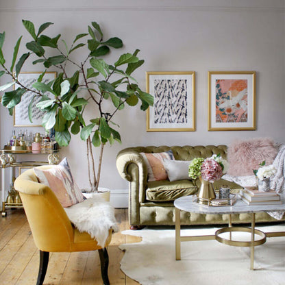 Living room with green sofa, yellow armchair, and decorative elements.