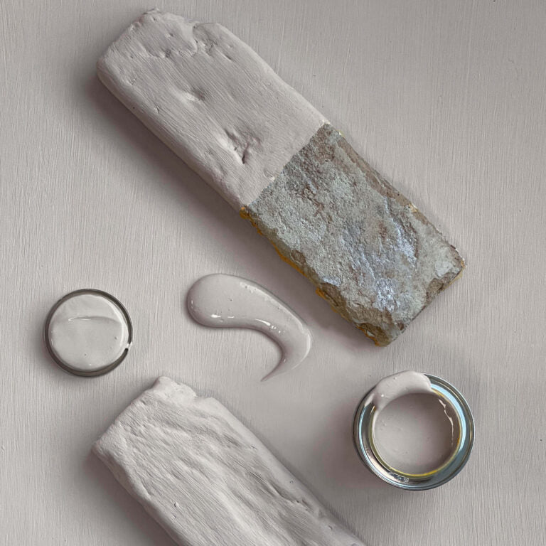 Close-up of a stone with a dollop of cream-like substance on a light background