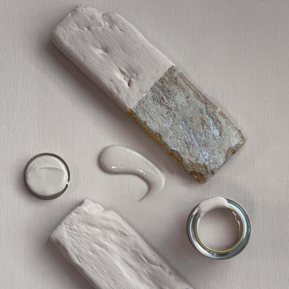 Close-up of a stone with a dollop of cream-like substance on a light background