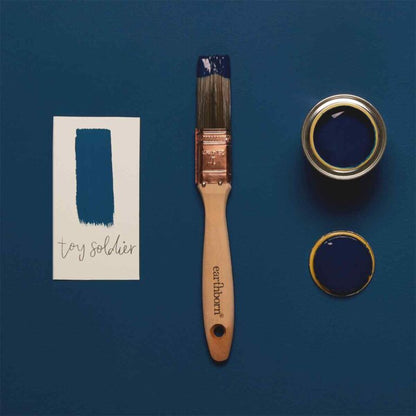 Paintbrush and paint can with 'toy soldier' color swatch on a blue background