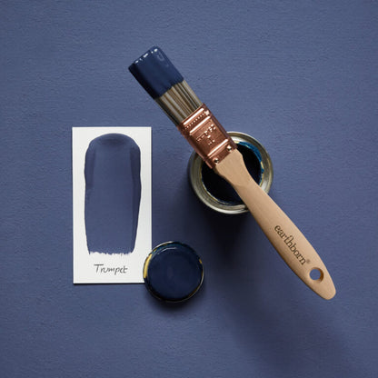 Paintbrush with blue paint and color swatch on a blue background