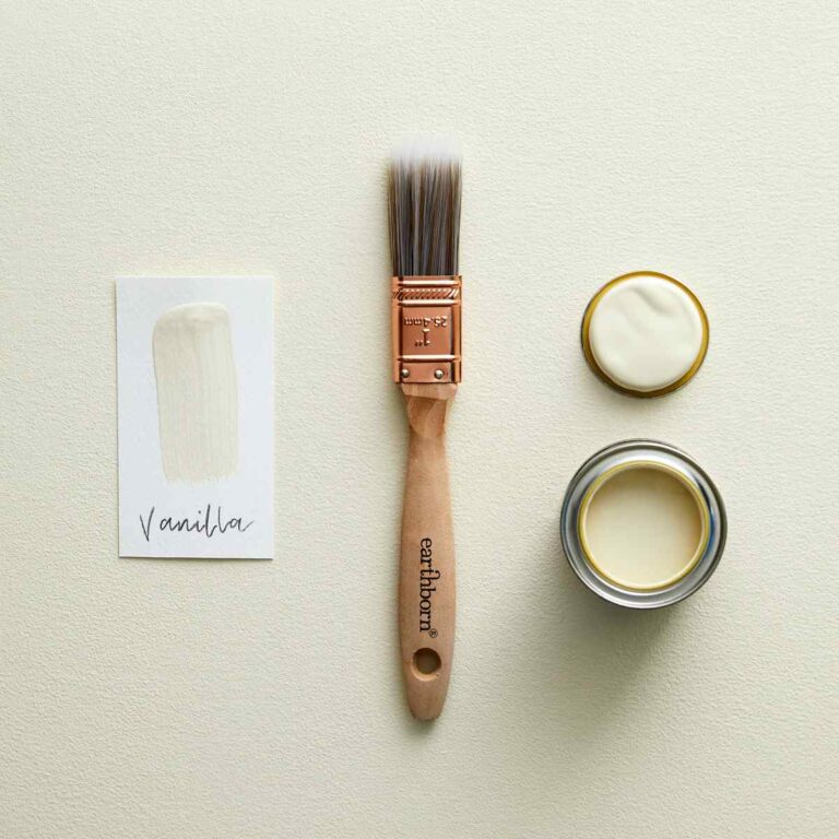 Paintbrush and two containers of vanilla paint on a light beige background
