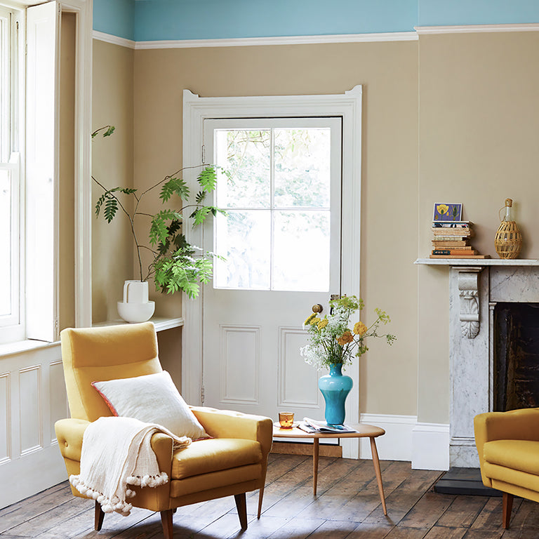 Living room with yellow armchair, coffee table, and decorative items.