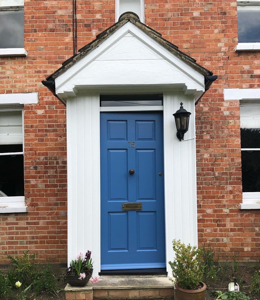 Blue door on a brick house with white trim
