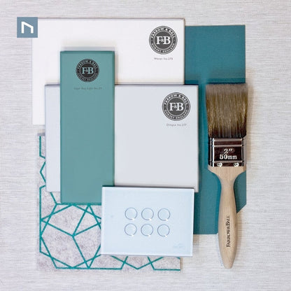 Packaging with teal and white boxes, a paintbrush, and branded elements on a textured surface.