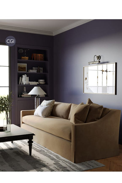 Living room with beige sofa, mirror, and bookshelf.