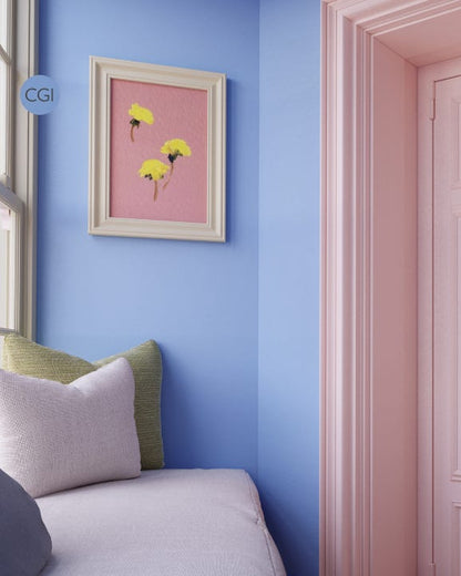 Room interior with a blue wall, framed artwork, and a bed with pillows.