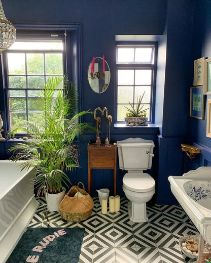 Bathroom with blue walls, white fixtures, and decorative elements.