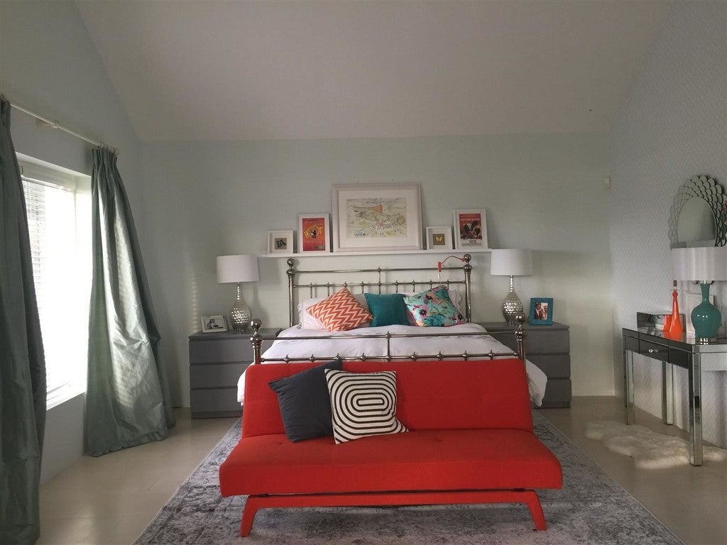 Modern bedroom with red sofa, bed, and decor