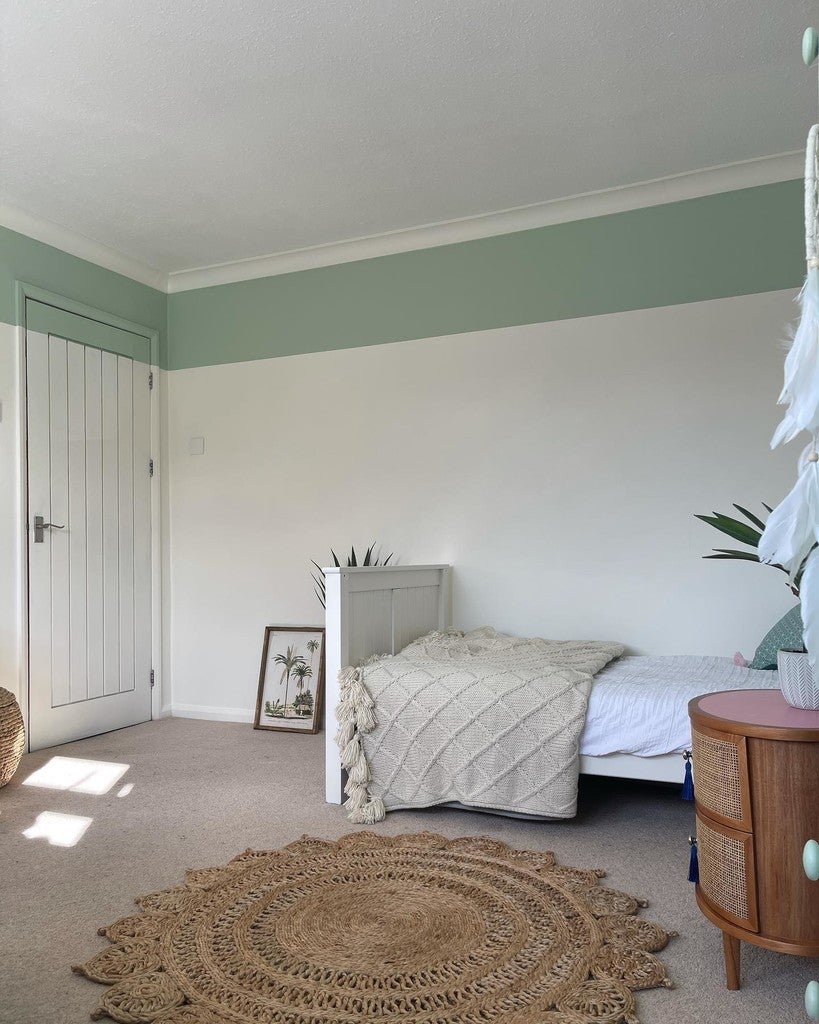 Neatly arranged bedroom with a bed, side table, and decor items.