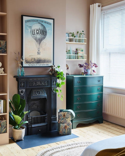 Room interior with a fireplace, teal dresser, and decorative items.