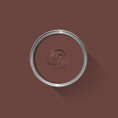 Close-up of a brown paint swatch with a silver ring on a brown background