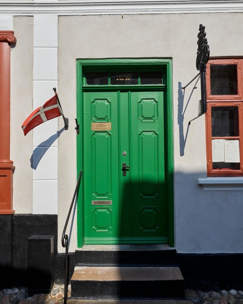Green door with a Danish flag on a building facade