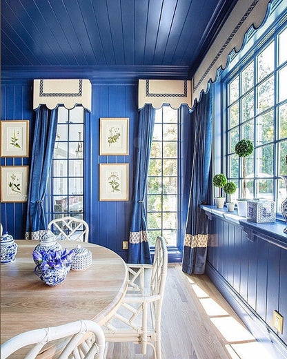 Dining room with blue walls, white trim, and large windows.