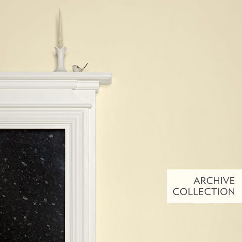 White fireplace with black hearth against a light yellow wall, featuring 'Archive Collection' text.