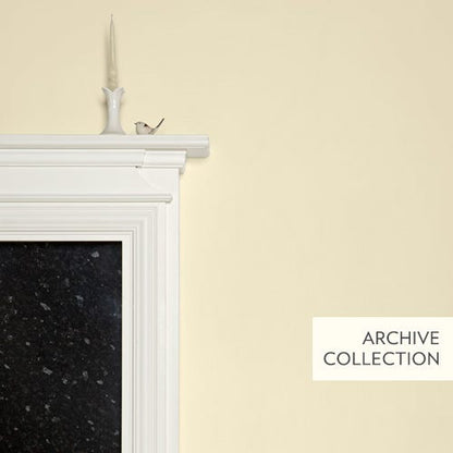 White fireplace with black hearth against a light yellow wall, featuring 'Archive Collection' text.