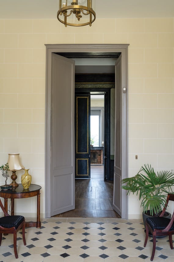 Interior hallway with open door leading to another room, featuring a patterned floor and decorative elements.