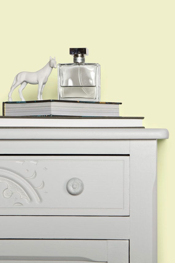 Decorative items on a dresser with a plain background