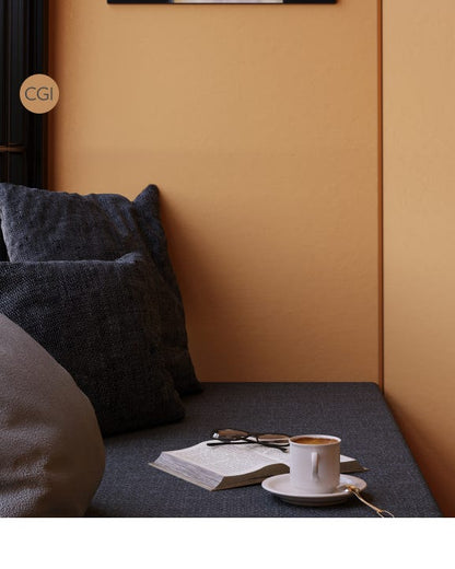 Couch with a cup of coffee, book, and sunglasses on a mustard yellow wall.